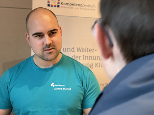Ein Mitarbeiter der Sanitherm Peter Schumacher GmbH (im Firmen-T-Shirt) spricht mit einem Interessenten.