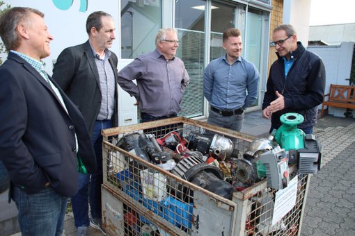 Martin und Sebastian Söll von der Firma Sanitherm übergeben in einer Gitterbox gesammelte Pumpen zum Recycling. 